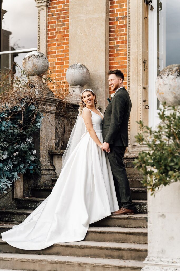 Newlyweds bride and groom stood on wedding venue steps