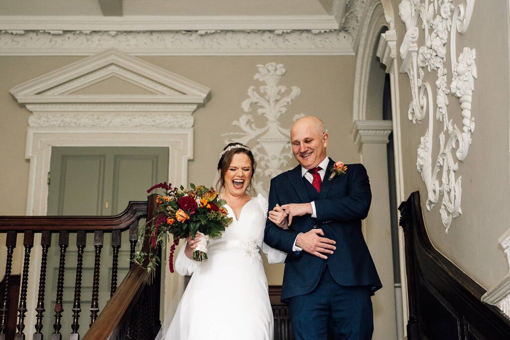 Bride walks down stairs to her wedding at Crowcombe Court