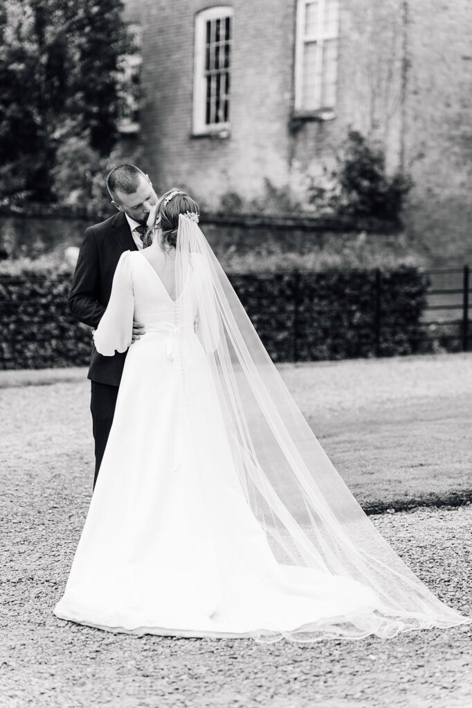 A black & white photo showing the back of the bride's wedding dress